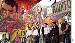 Hostages stand guarded on stage in a film theatre in San Salvador Atenco 