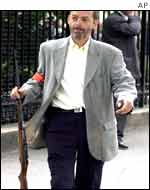 Plainclothes police officer carries seized rifle