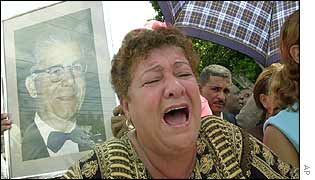 A mourner takes up position outside Mr Balaguer's home to show her grief