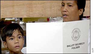 A boy looks at his mothers choice for village officials at a polling precinct in Manila