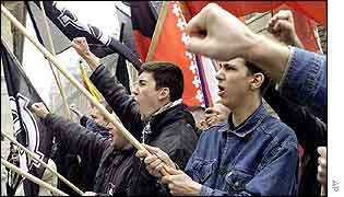 Maxime Brunerie, in denim jacket, shown holding a flag (far right)