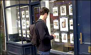 Man looking in estate agent's window