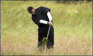 Woods pushes his opening shot into the thick rough on the right side of the hole 