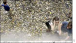People freshen up at water sprays on the pebble-covered banks