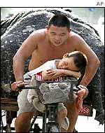 A man cycles with his child in Beijing