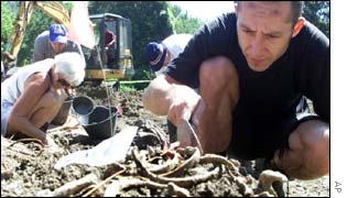 Members of the International Commission on Missing Persons in Bosnia inspect body remains found in the mass grave 