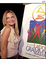 Chilean singer Nicole pauses by a poster of the 3rd Annual Latin Grammy Awards during the nomination news conference in Beverly Hills Wednesday, July 24, 2002