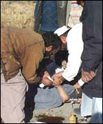 A young Afghan boy receives emergency treatment after standing on an anti-personnel mine