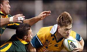 Corne Krige and Andre Pretorius try to prevent Ben Tune from scoring Australia's opening try