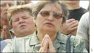 People pray at a ceremony held at the site of the crash