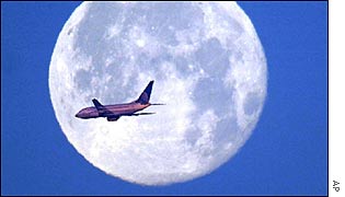 Commercial jet in front of moon