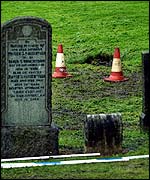 Cones mark the hole in the cemetery