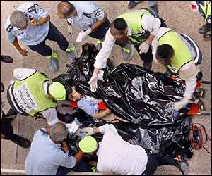 Police and volunteers examine the body of one of the dead victims (AP)