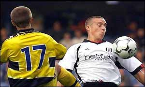 Sean Davis of Fulham is tackled by Benoit Pedretti of Sochaux
