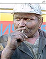 A miner smokes as he watches the rescue works at the Zasyadko mine