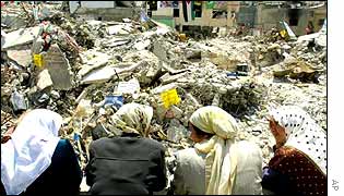 Women in Jenin look at the rubble after fighting in April