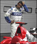 Juan Pablo Montoya scratches his head as he looks at Michael Schumacher's Ferrari this year