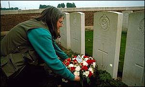 Woman laying flowers on grave in Ypres