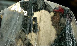 A television camera operator shelters from the torrential rain at the City of Manchester stadium 