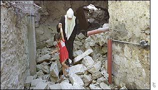 Family of Palestinian man wanted by Israeli authorities walk across rubble of their home