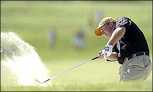 Graeme McDowell hits his way out of a bunker on the 13th hole