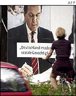 Cyclist passes Schroeder poster