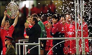 Sami Hyypia of Liverpoool holds the Charity Shield aloft in front of manager Gerrard Houllier last season
