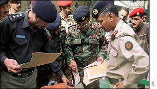 Police and Pakistan Army officers examine a bag left by the gunmen 