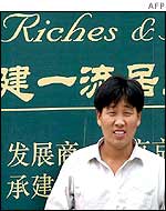 Man in front of a property sign in Shanghai