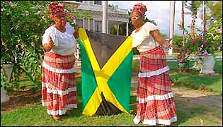 Two Jamaican women hold up the national flag