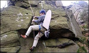 Man abseiling with ironing board on his back