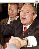 US President George W Bush shakes hands and waves to the crowd as he leaves the crowed gymnasium in Madison, Mississippi.