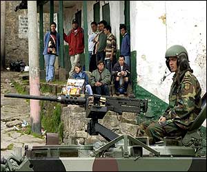 Soldier on a tank in bombed neighbourhood