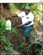 Worker in Louisiana sprays pesticide in a ditch 