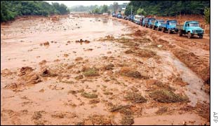 Trucks make their way down a highway washed away by landslides in Ma An Shan, in central Anhui province on 9 August 