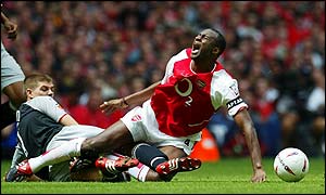 Steven Gerrard of Liverpool brings down Patrick Vieira 
