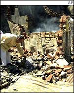 A businessman sorts out from the debris after rioters attacked the area 