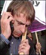 A campaigner listens for news on a mobile phone