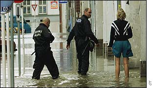 Police question a woman in a flooded suburb of Prague