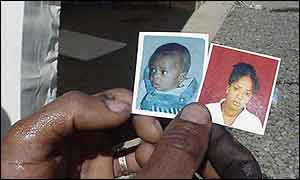 Ambassanger Hailu holding photos of his wife and son