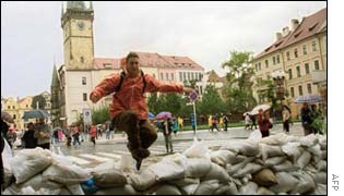 A tourist jumps over sandbags in the Old Town