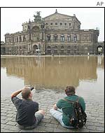 People sit in front of the Semper Opera House in Dresden