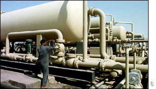 An Iraqi oil worker checks pipes at the West Qurna oil field in Iraq