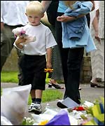 a child lays flowers at St Andrews church