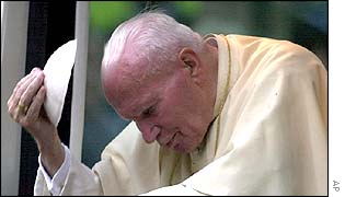 The Pope removes his skull cap at his parents' grave