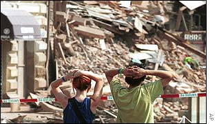 Young people gaze at the remains of three fallen buildings