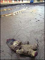 Teddy bear lying on a muddy street