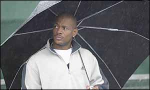 Maurice Greene shelters under an umbrella