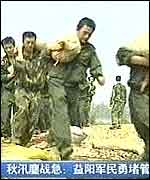 Chinese soldiers carrying sand bags