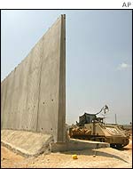 An Israeli armoured personnel carrier guards a gap in the newly built wall separating the West Bank town of Qalqiliya from Kfar Saba in Israel